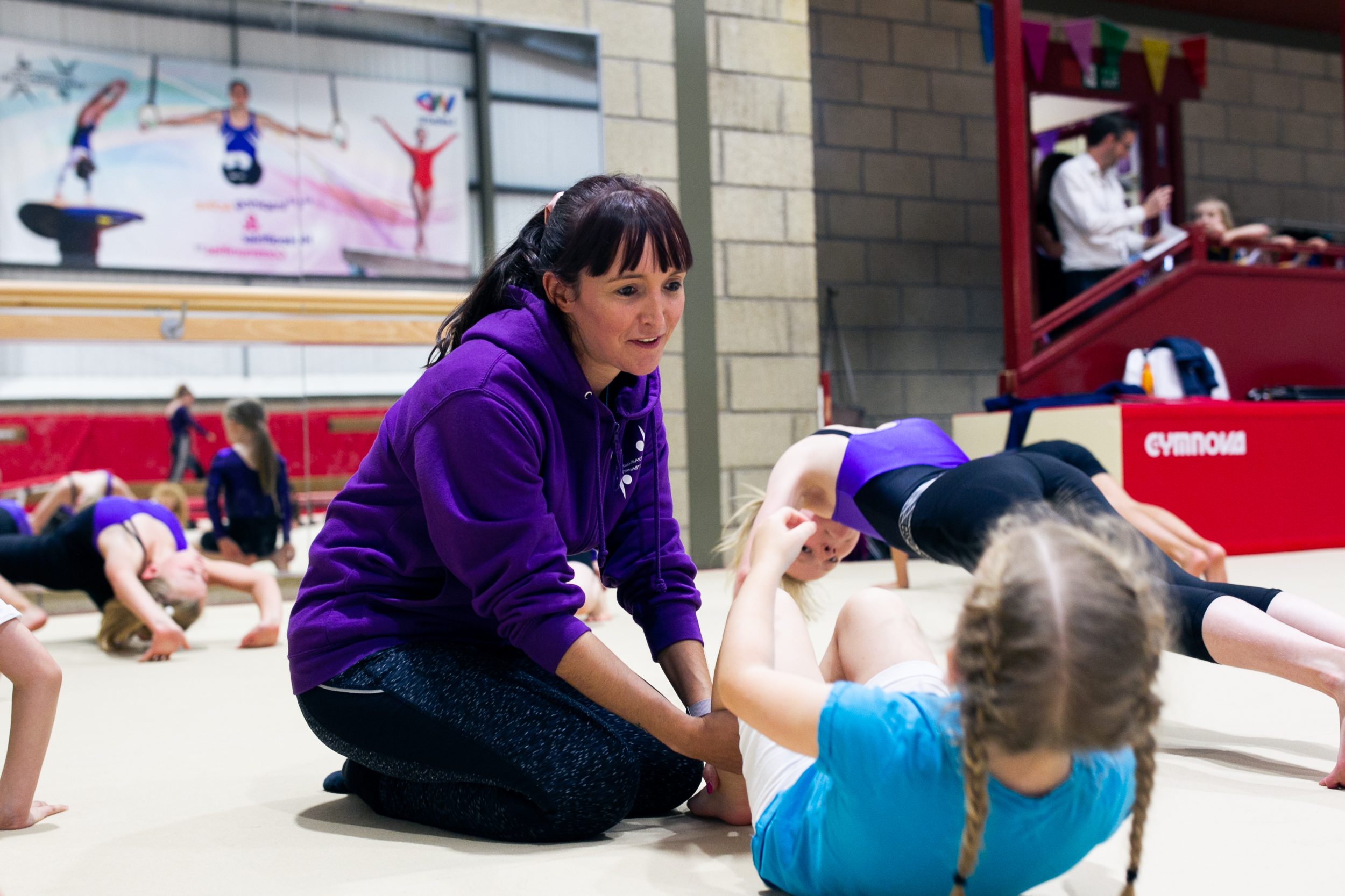 A coach delivers training for school age gymnasts