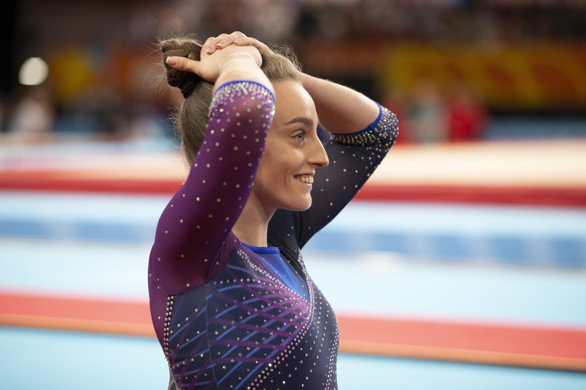 Gymnast Shannon Archer smiling with hands on head after realising she won a Commonwealth Games medal